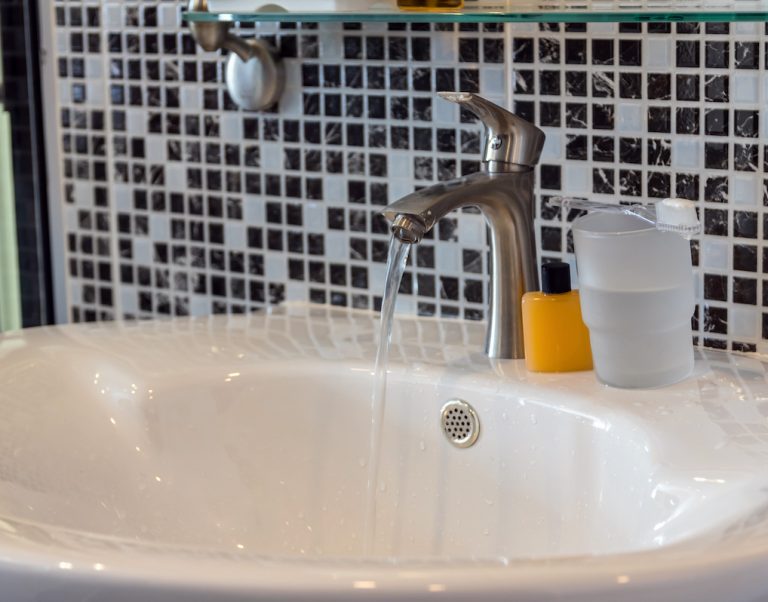 Chrome faucet with washbasin in modern bathroom